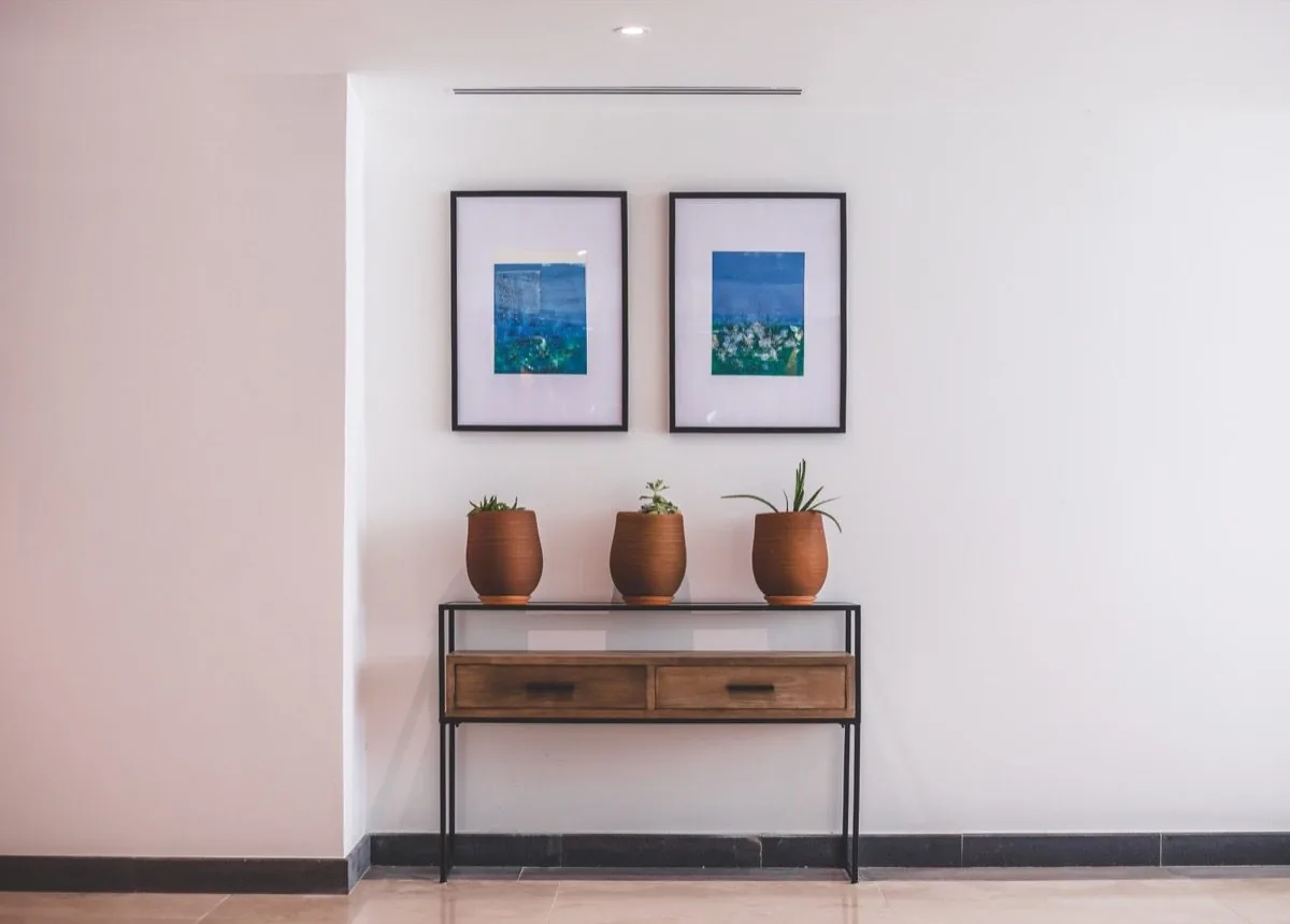 A quiet corridor, two paintings, three pots.